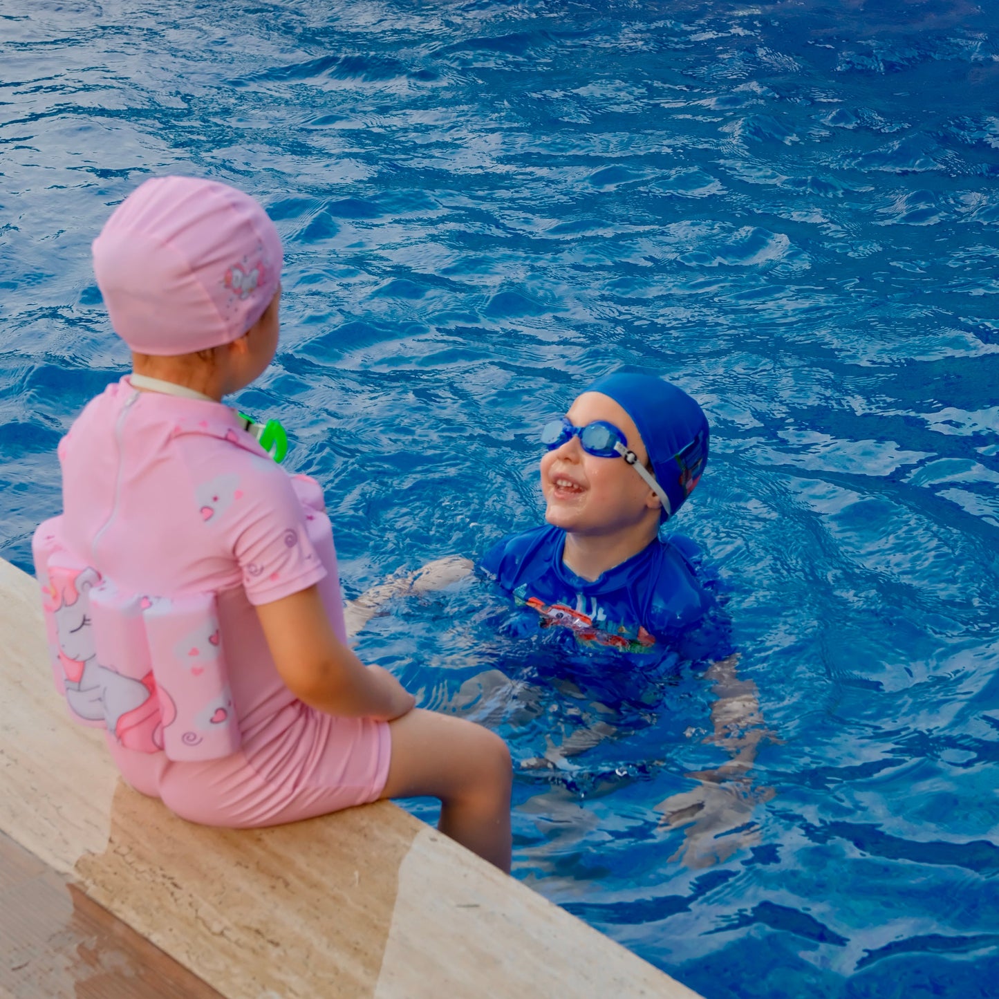 KidVision yüzdüren mayo giyen çocuk havuzda yüzerken